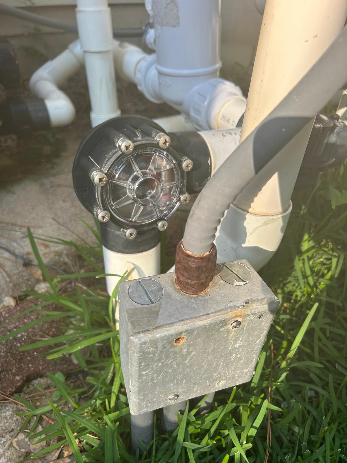 Newly installed clear lid pool check valve with stainless screws fitted to the plumbing at a Houston pool equipment pad