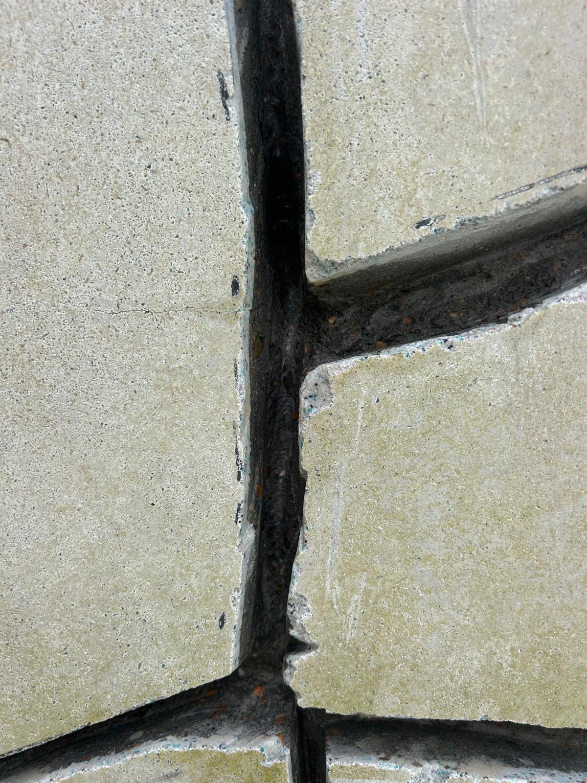 Close up of a pool wall crack chased into a clean V groove down to sound gunite before it is filled