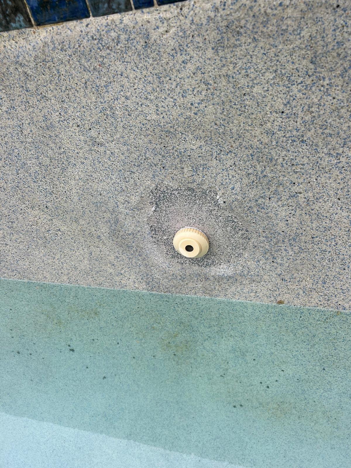 New return eyeball fitting set into a fresh plaster patch on a pool wall after a pressure side leak repair
