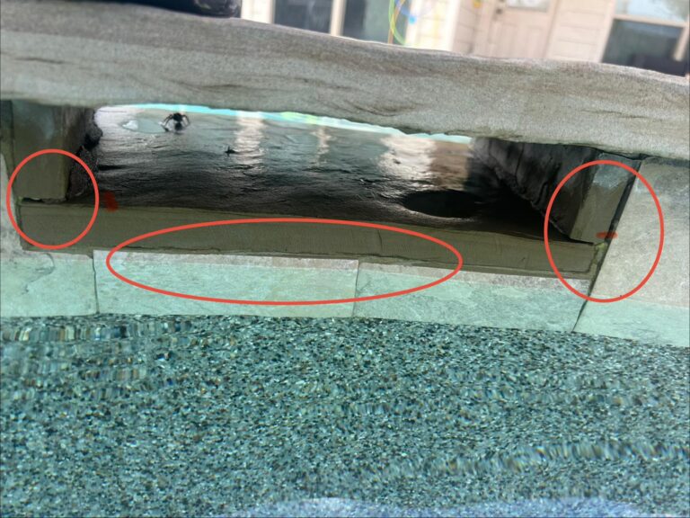 Inspection photo with cracks circled in red along the horizontal joint and end returns of a stone spa spillover