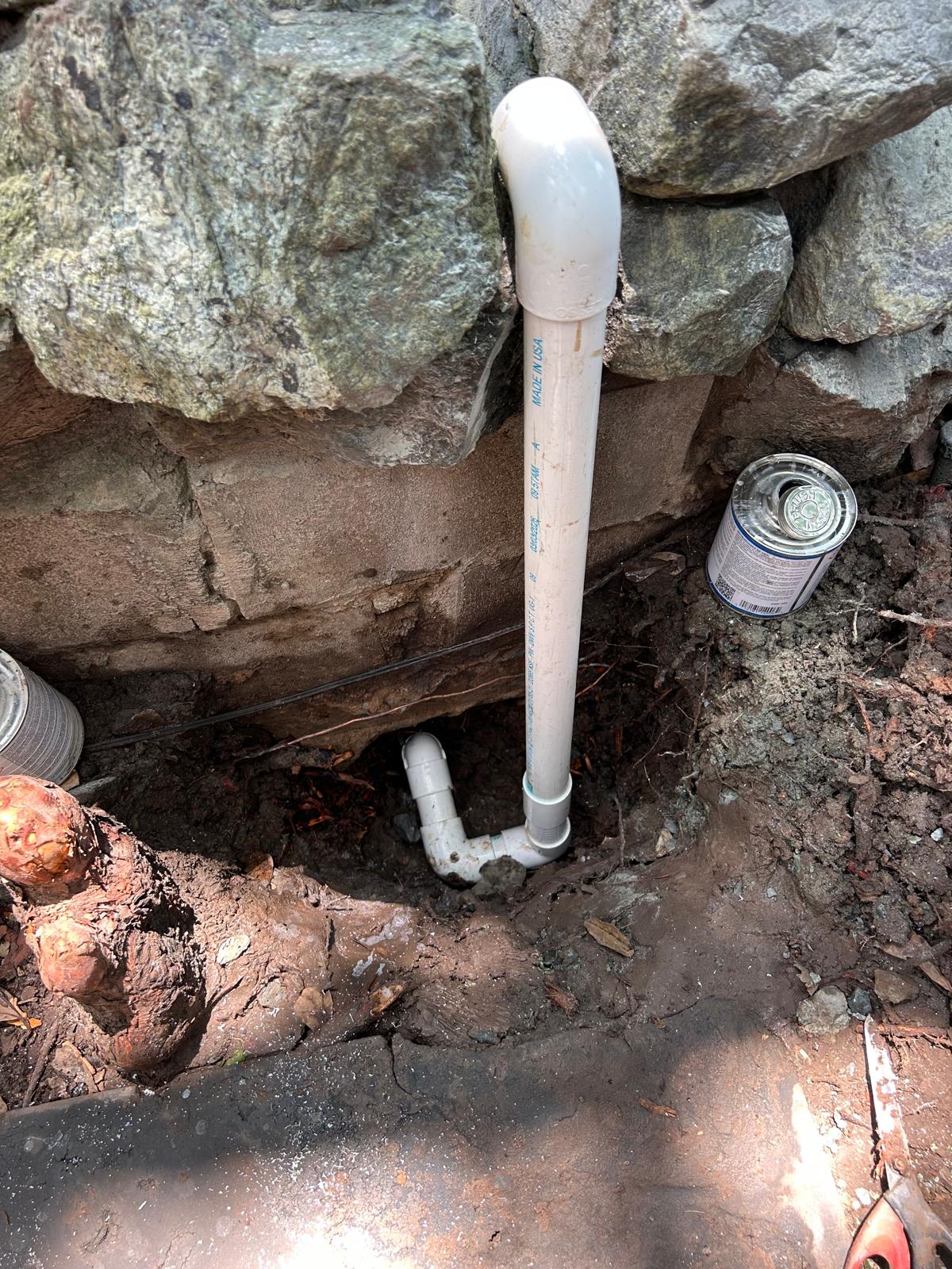New PVC riser plumbed up behind a rock waterfall to bypass an unreachable leaking water feature line
