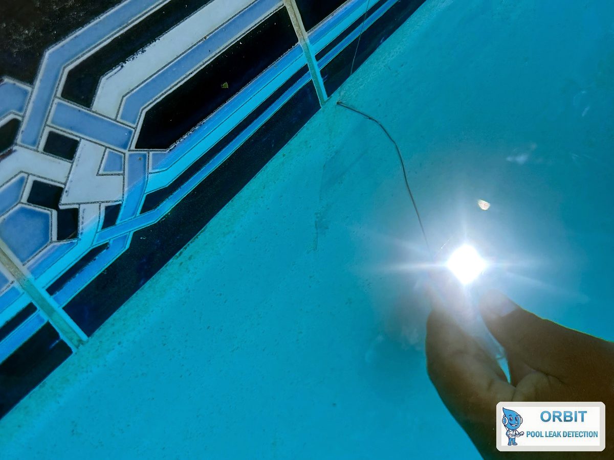 Technician dye testing a corner crack on a concrete pool in Houston, TX